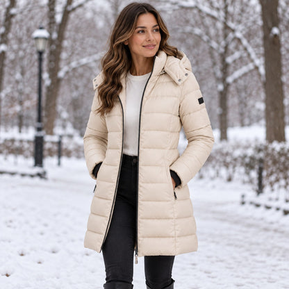 Beige long hooded puffer coat in a snowy park